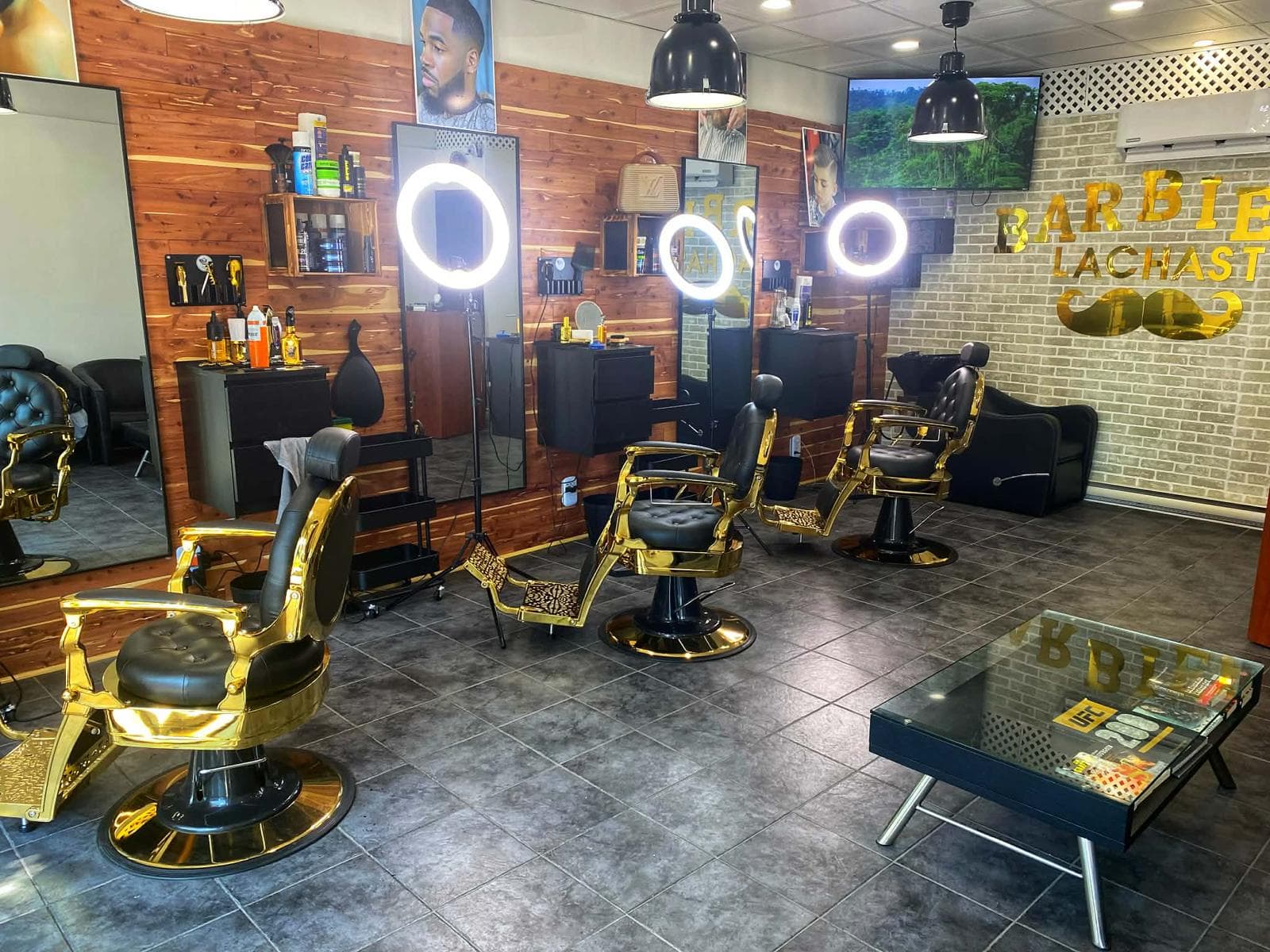 Intérieur du barbershop Barbier La Chast avec chaises dorées et décor premium